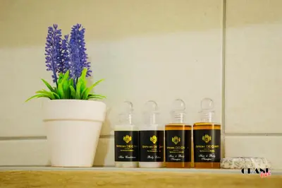 a shelf with three bottles of honey and a potted plant at GRAND LUX Mihajlo in Doboj