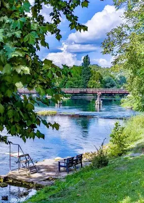 two benches and a train on a bridge over a river at Watermill 102 - Apartment Krupana in Bosanska Krupa