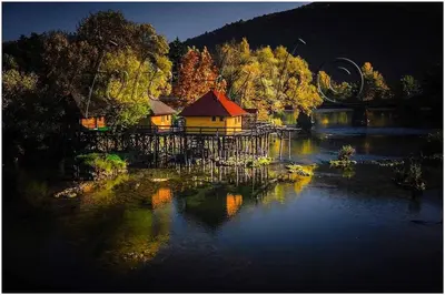 a house in the middle of a lake at night at Watermill 102 - Apartment Krupana in Bosanska Krupa
