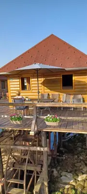 a wooden deck with a house with a table and chairs at Watermill 102 - Apartment Krupana in Bosanska Krupa