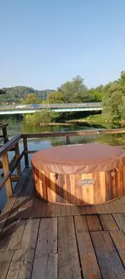 a round wooden table on a wooden deck at Watermill 102 - Apartment Krupana in Bosanska Krupa