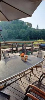 a table and chairs on a deck with an umbrella at Watermill 102 - Apartment Krupana in Bosanska Krupa