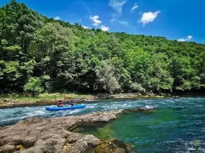 a person in a blue boat on a river at Watermill 102 - Apartment Krupana in Bosanska Krupa