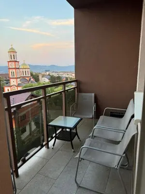 a balcony with chairs and a table and a building at Apartman Vera in Banja Luka