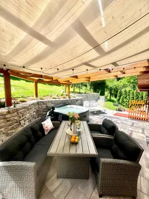 a patio with a couch and a table under a pergola at Apartmani Lara&Sara in Bihać