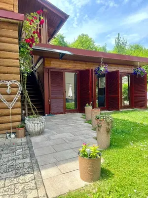 a house with a patio with potted plants in the yard at Apartmani Lara&Sara in Bihać