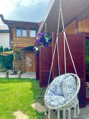 a swing in a yard in front of a house at Apartmani Lara&Sara in Bihać