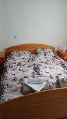 a bedroom with a bed with a wooden frame at Apartman Melani in Kupres
