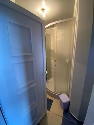a bathroom with a shower and a toilet and a door at Apartman Melani in Kupres