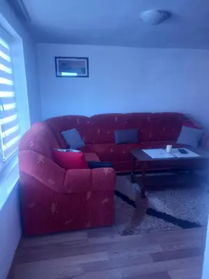 a red couch in a living room with a table at Apartman Melani in Kupres