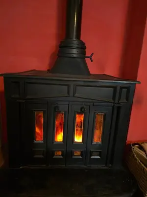 a black stove with fire inside of it at Apartman Melani in Kupres