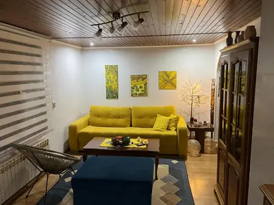 a living room with a yellow couch and a table at Apartman SI in Banja Luka