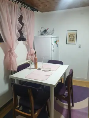 a white table with chairs and a white refrigerator at Apartman SI in Banja Luka