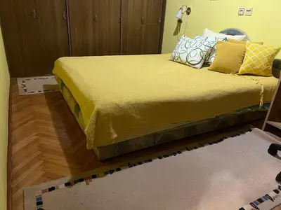 a bedroom with a bed with a yellow bedspread at Apartman SI in Banja Luka