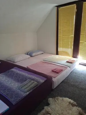 two twin beds in a room with a window at Natural House in Visoko