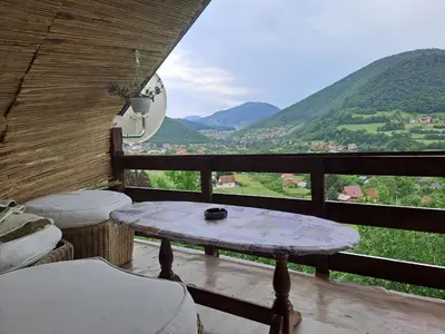 a table on a balcony with a view of mountains at Natural House in Visoko