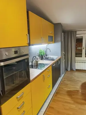 a kitchen with yellow cabinets and a sink at Prestige Banja Luka in Banja Luka