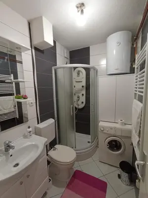 a bathroom with a shower toilet and a sink at Apartman Dina in Bihać