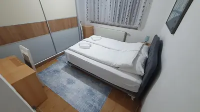 a small bed in a room with a window at Apartman Dina in Bihać