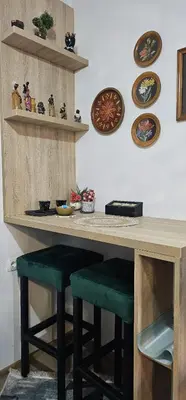 a kitchen with a counter with stools and plates on the wall at Apartmani blue i green in Bugojno
