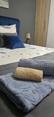 a bed with two pillows and a rug on it at Apartmani blue i green in Bugojno