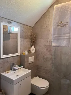 a bathroom with a white toilet and a sink at Apartmani Subotic in Bosanska Gradiška