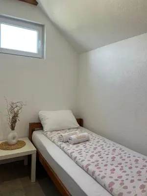 a small bedroom with a bed and a window at Apartmani Subotic in Bosanska Gradiška
