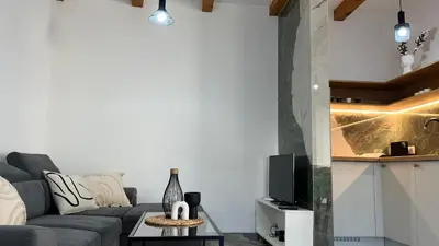 a living room with a gray couch and a tv at Apartmani Subotic in Bosanska Gradiška