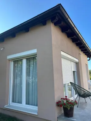 a house with a window and a chair in front of it at Apartmani Subotic in Bosanska Gradiška