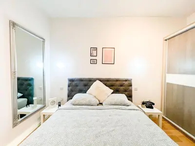 a bedroom with a large bed and a mirror at DAMI in Tuzla
