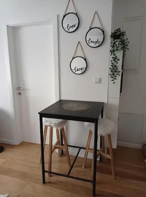 a black table and chairs in a room with two mirrors at DAMI in Tuzla