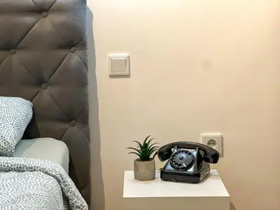 a telephone sitting on a table next to a bed at DAMI in Tuzla