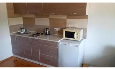a small kitchen with a microwave and a refrigerator at Apartman Stari Travnik in Travnik