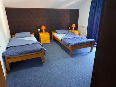 a bedroom with two beds and two lamps on night stands at Apartman Stari Travnik in Travnik