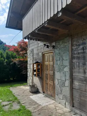 a stone building with a wooden door and a porch at River house - Riječna idila in Cazin