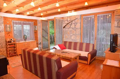 a living room with a couch and a table at River house - Riječna idila in Cazin