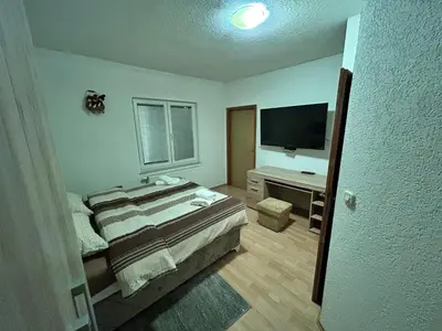a bedroom with a bed and a desk with a television at Apratmani Ivić in Kupres