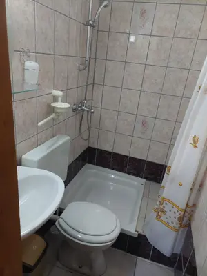 a bathroom with a toilet and a sink and a shower at Apratmani Ivić in Kupres