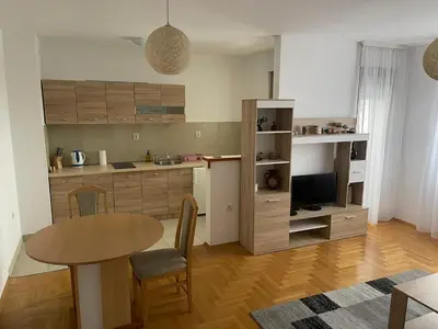 a kitchen with a table and a dining room at Apartman Lola in Banja Luka