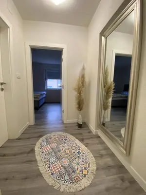 a hallway with a mirror and a rug on the floor at New World in Bihać
