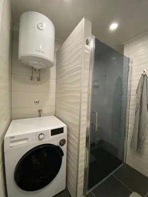 a washing machine in a bathroom with a shower at New World in Bihać