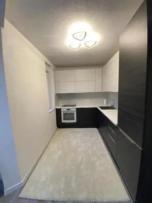 a small kitchen with white cabinets and a stove at New World in Bihać
