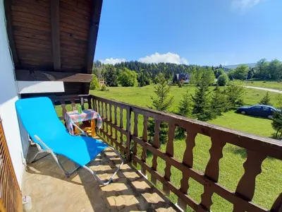 a blue chair sitting on a balcony with a table at Montecasa in Travnik