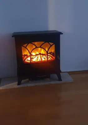 a black stove with a fire in a room at Studio Apartman Maša Kupres in Kupres