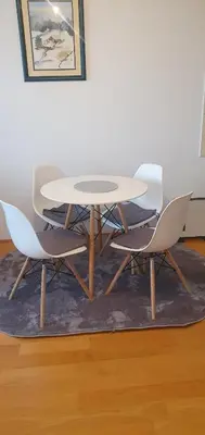 a white table and four chairs on a rug at Studio Apartman Maša Kupres in Kupres