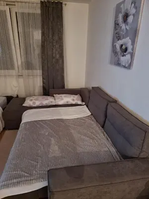 a couch with a bed in a living room at Studio Apartman Maša Kupres in Kupres