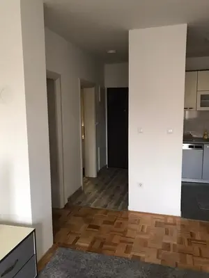 a kitchen with white walls and a wooden floor at Apartman Jaca in Tuzla
