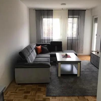 a living room with a couch and a coffee table at Apartman Jaca in Tuzla