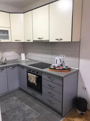a kitchen with white cabinets and a stove top oven at Apartman Jaca in Tuzla