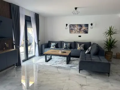a living room with a blue couch and a table at Villa Nejra in Bihać